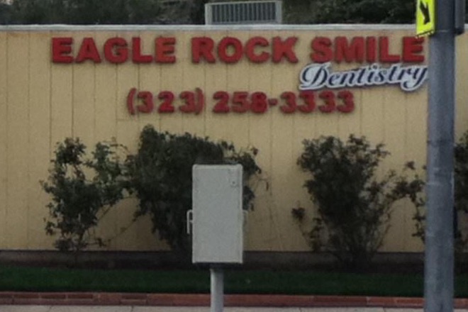 The painted sign across the front of the office, reading Eagle Rock Smile Dentistry above the phone number